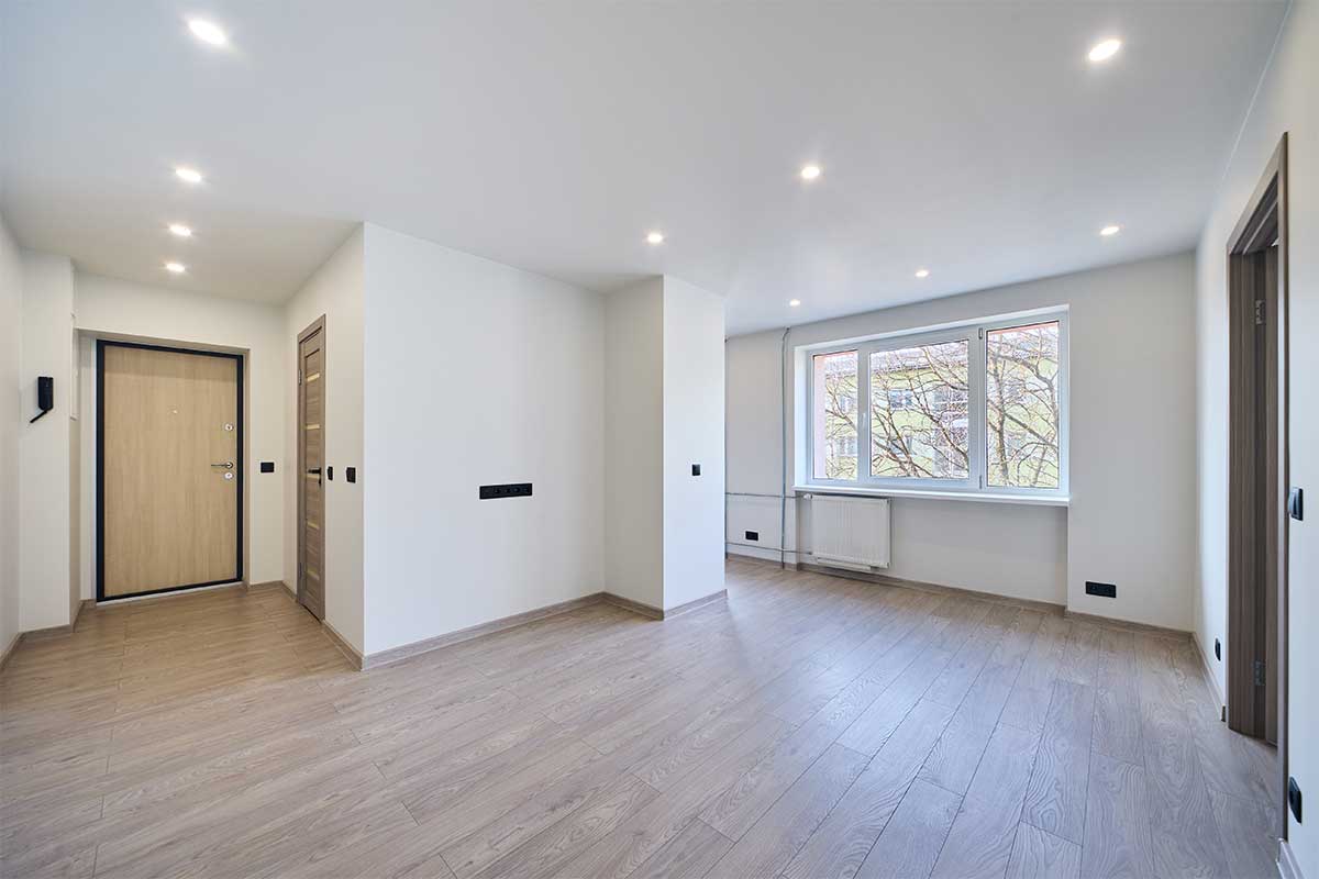Modern empty apartment interior ready for sale or rent. Bright minimalistic hallway with wooden floor in a new residential building. Real estate investment, property development and housing market